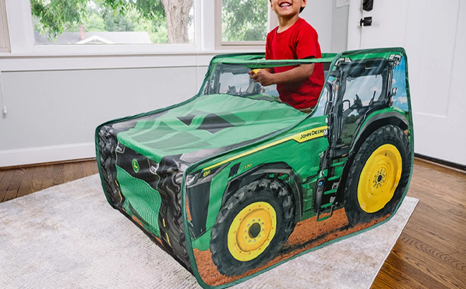 A Person playing in a John Deere Tractor Pop Up Tent