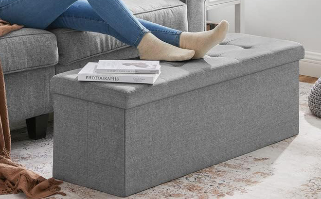 A Person resting their Legs on a Storage Ottoman Bench