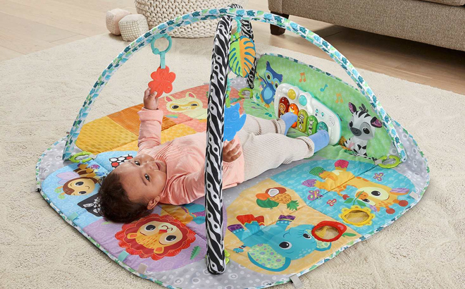 A Toddler Laying on the VTech 7-in-1 Senses & Stages Developmental Gym