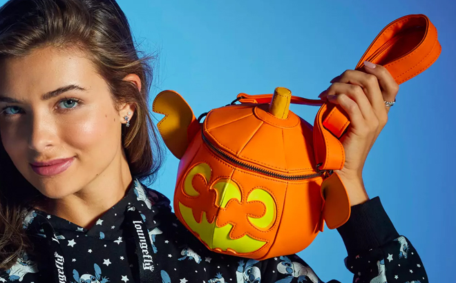 A Woman Holding Disney Stitch Glow-in-the-Dark Loungefly Jack-o'-Lantern Crossbody Bag