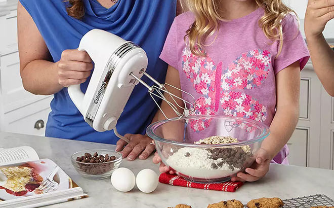 A Woman Holding the Cuisinart Power Advantage 9 Speed Hand Mixer