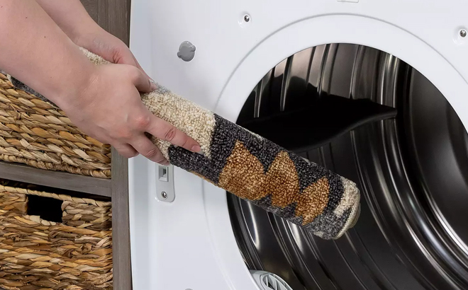 A Woman Putting the Sonoma Goods For Life Washable Throw Rug in the Washing Machine