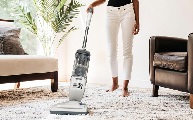 A Woman Using Shark Navigator Freestyle Bagless Cordless Upright Vacuum