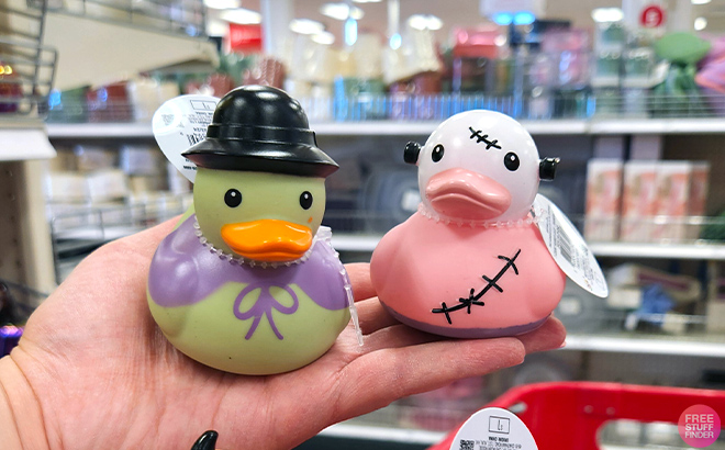 A hand holding a Witch and Frankenstein Rubber Ducks