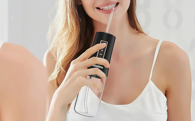 A lady using iHealthia Cordless Water Flosser