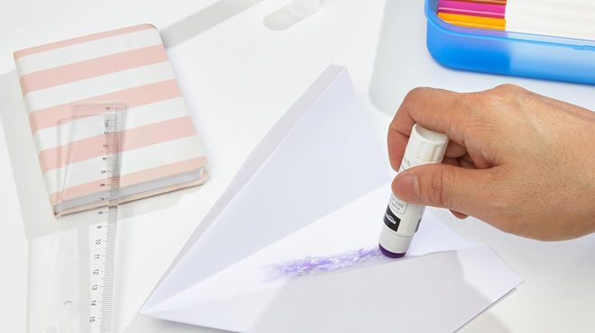 A person using an Amazon Basics Purple Washable Glue Stick