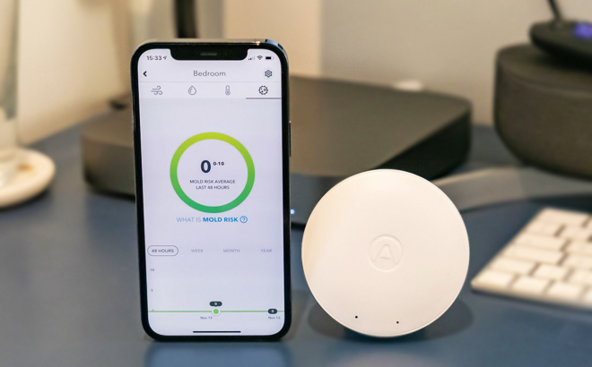 Airthings Wave Mini Air Quality Sensor and Phone on a Table