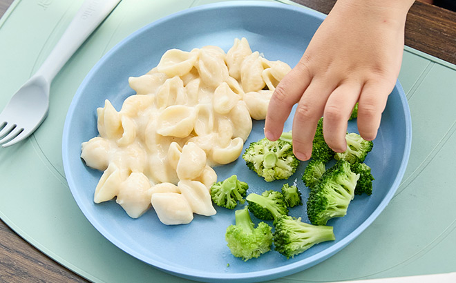 Kid Reaching for Food on a Plate