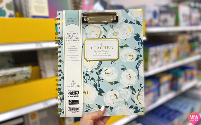 A Person Holding a Teacher Planner inside a Store