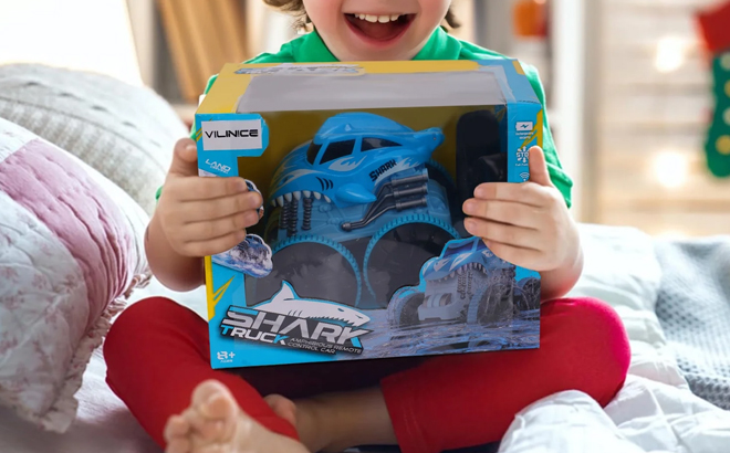 A Boy Holding the Vilinice Remote Control Shark Monster Truck Toy