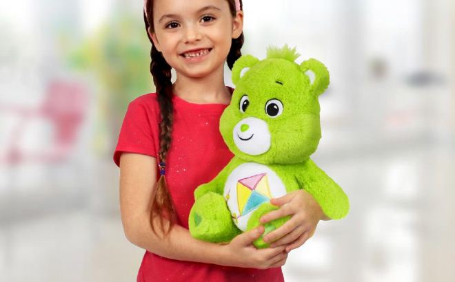 A Child Holding a Care Bears 14 Inch Do Your Best Bear