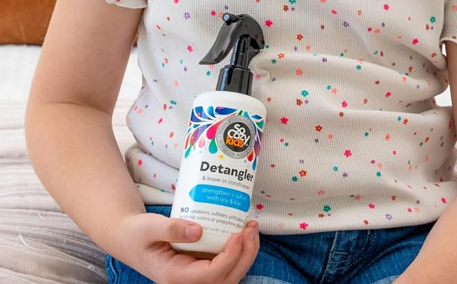 A Child Holding the So Cozy Detangler Leave In Conditioner Spray