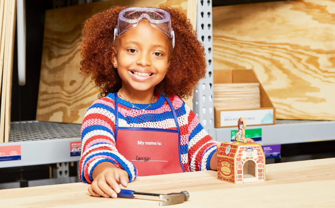 A Girl Building a Fire Dog Bank at Lowes Workshop