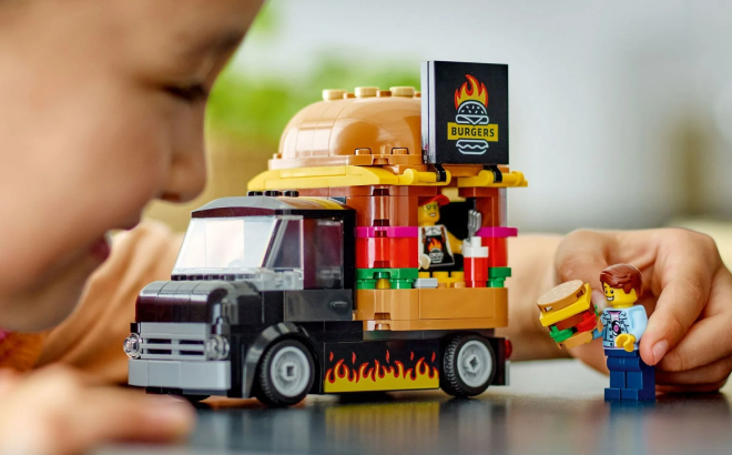 A Kid Playing with LEGO City Burger Truck Building Set