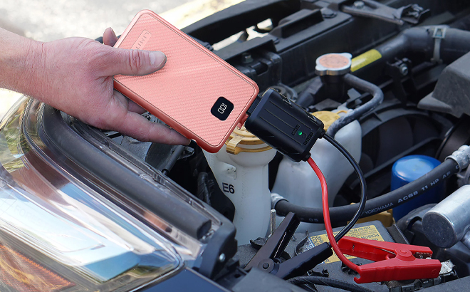 A Man Holding Limitless AutoBoost 3-in-1 Jump Starter, Power Bank & Light