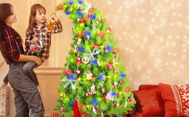 A Mother and Daughter Putting Christmas Balls on Grinch Christmas Tree