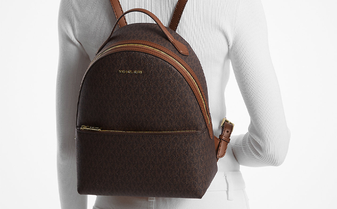 A Person Carrying the Michael Kors Sheila Medium Logo Backpack in Brown