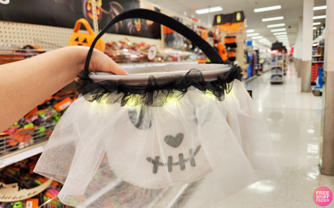 A Person Holding a Hyde EEK Light Up Halloween Pail in Skull Design