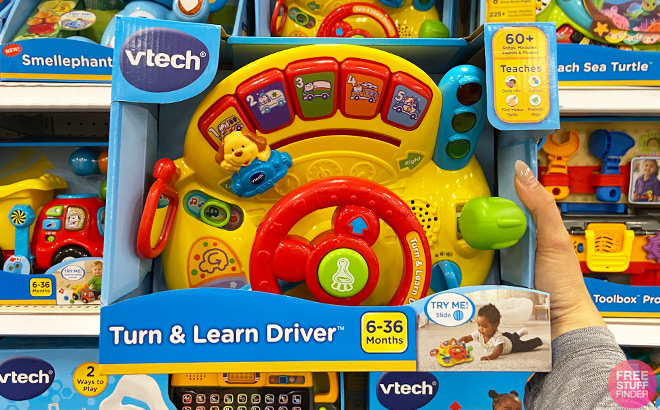 A Person Holding a VTech Turn and Learn Driver Toy