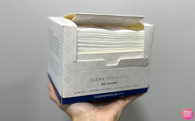 A Person Holding the Clean Skin Club Clean Towels XL 50 Count