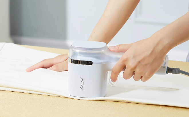 A Person Ironing Pants Using Salav Quicksteam Travel Steamer