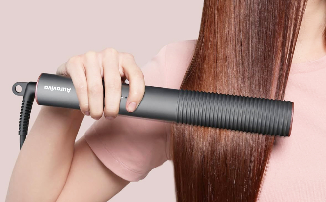 A Person Straightening her Hair Using Auraviva Brush