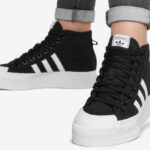 A Person Wearing Adidas Nizza Platform Mid Shoes