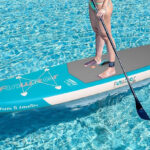 A Person standing on a Funwater Inflatable Paddle Board in Dark Green Color