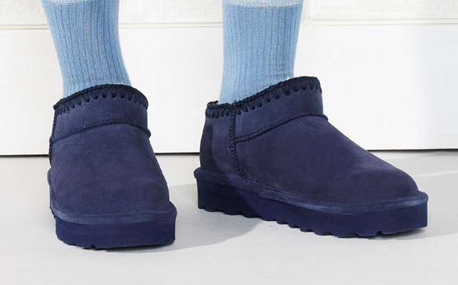 A Person wearing Bearpaw Lana Crochet Suede Ankle Booties in Indigo Color 