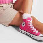 A Person wearing Chuck Taylor All Star Canvas High Top Shoes in Fuchsia Color