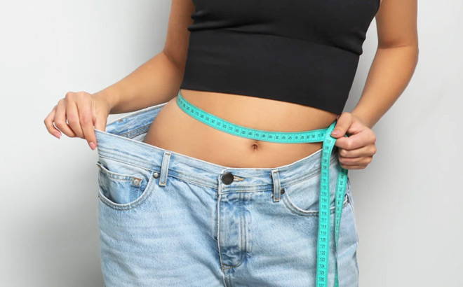 A Woman Holding Her Large Jeans to Show Her Successful Weight Loss Journey