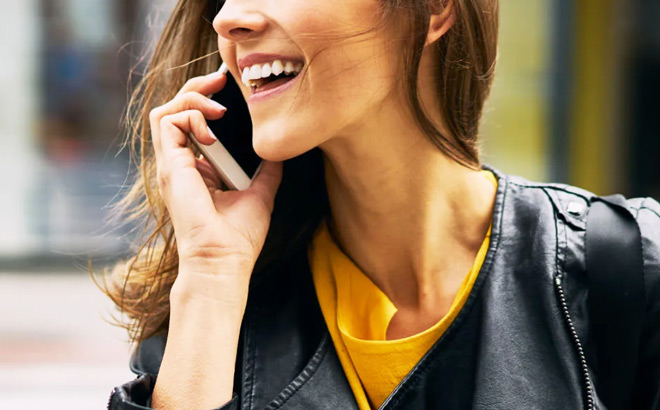 A Woman in the Street Talking on a Mobile Phone and Smiling