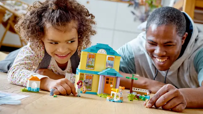 A child and a father playing with LEGO Paisleys House