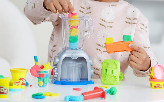 A child playing with a Play Doh Swirlin Smoothies Toy Blender Playset