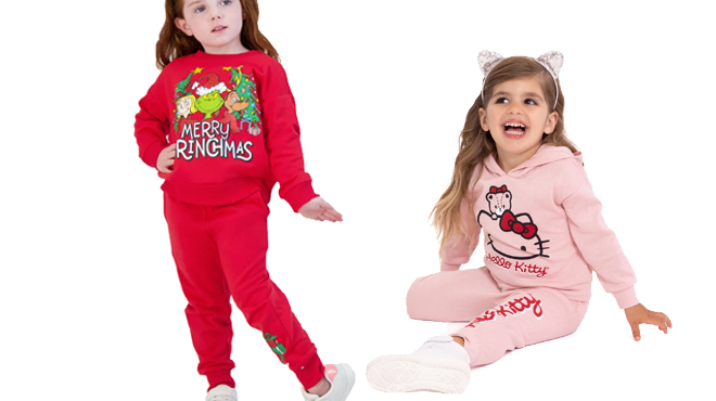 A girl wearing a Grinch Toddler Sweatshirt Jogger Set and Hello Kitty Girls Graphic Hoodie Joggers Set