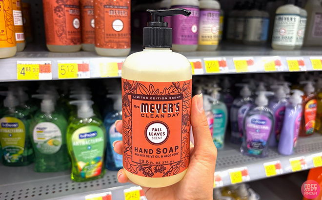 A hand holding Mrs Meyers Clean Day Fall Leaves Scent Hand Soap