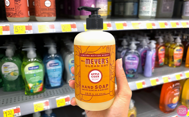 A hand holding Mrs Meyers Clean Day Liquid Hand Soap