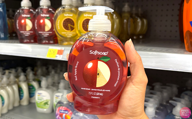 A hand holding Softsoap Red Apple Liquid Hand Soap