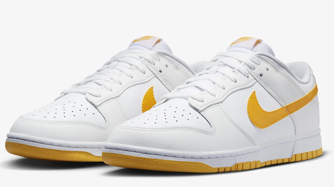 A pair of Nike Dunk Low Retro Mens Shoes in University Gold color