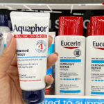 A person holding Aquaphor Healing Ointment