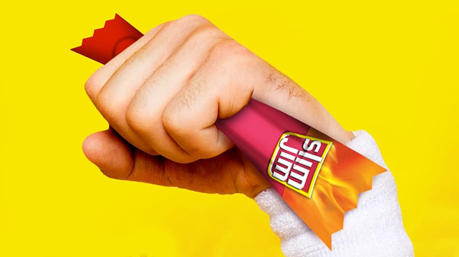 A person holding a Slim Jim Original Smoked Meat Sticks