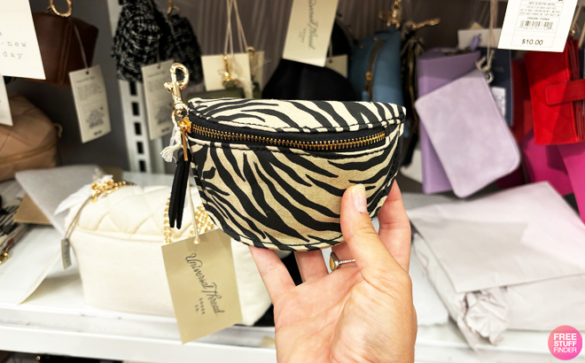 A person holding a Universal Thread Belt Bag Pouch Wristlet in black zebra striped color