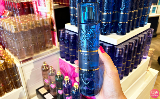 A person holding a bottle of Bath Body Works On The Horizon Fragrance Mist