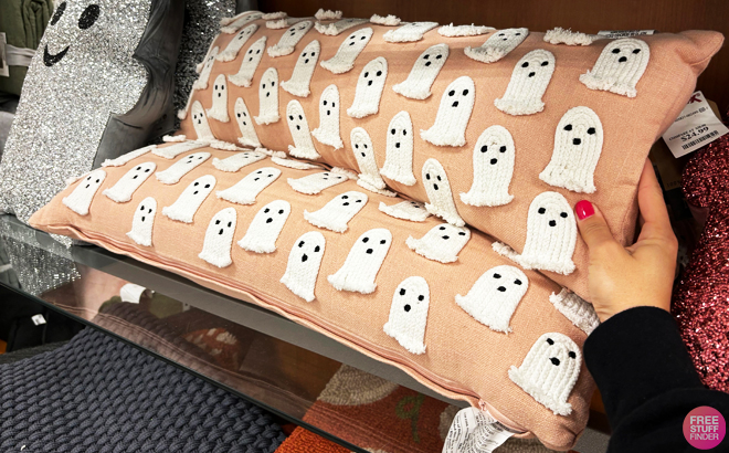 A person holding a ghost decorative pillow