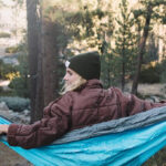 A person lounging on a Wise Owl Outfitters Camping Hammock