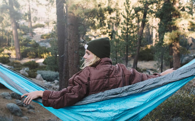 A person lounging on a Wise Owl Outfitters Camping Hammock