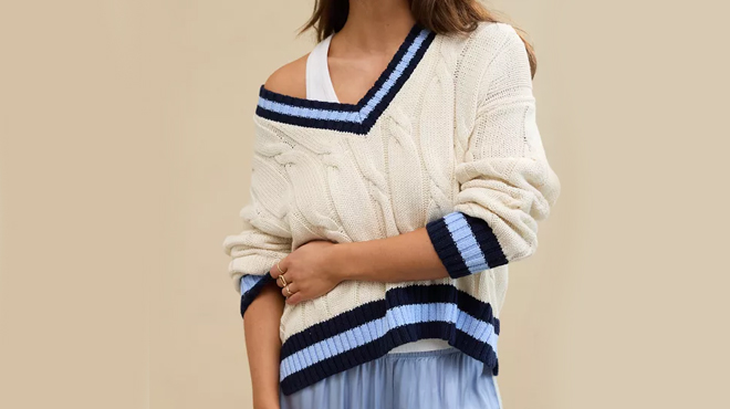 A person wearing Aerie Cropped Cable V Neck Sweater