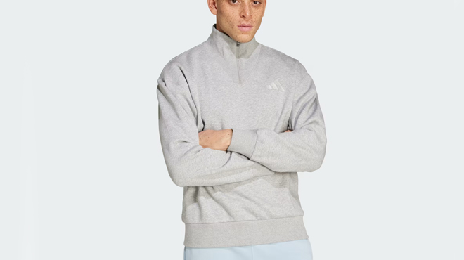 A person wearing a Adidas Fleece Quarter Zip Crew Sweatshirt