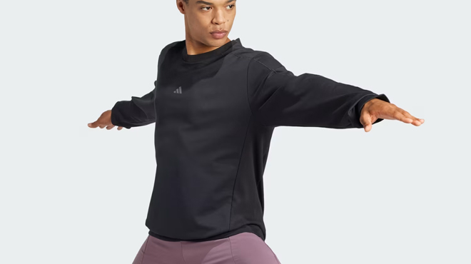 A person wearing a Adidas Yoga Crewneck Sweatshirt