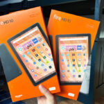 Hand Holding two Amazon Fire HD 10 Tablets